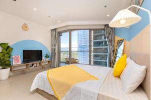 a bedroom with a large bed and a large window at The Sóng Apartments And Hotel 4 Stars in Vung Tau