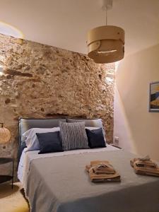 a bedroom with a bed with a stone wall at ESSE boutique homes in Cefalù