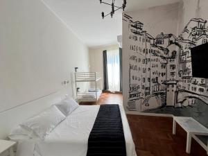 1 dormitorio con cama blanca y pared en blanco y negro en Be Your Home - Guest House Fuori Dal Porto, en Civitavecchia