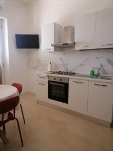 a kitchen with white cabinets and a stove top oven at Casa Quieta in Marina di Camerota