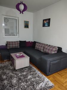 a living room with a couch and a table at Amethyst apartment in Igalo