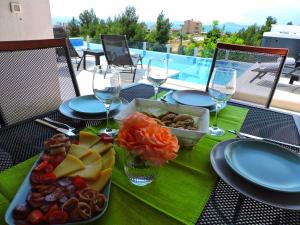 una mesa con una bandeja de comida y copas de vino en Villa Domus, en Podstrana