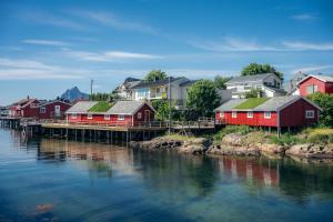 un gruppo di case su un molo vicino a un corpo idrico di Svinøya Rorbuer a Svolvær