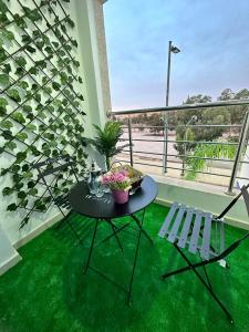 d'un balcon avec une table, des chaises et de l'herbe verte. dans l'établissement Familyconfort oujda, à Oujda