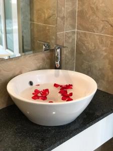 a white sink with red flowers in it on a counter at Hotel Hoai Anh in Vung Tau
