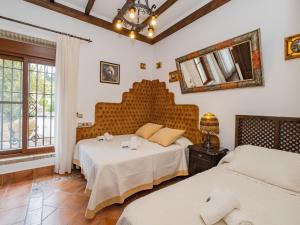 een slaapkamer met 2 bedden en een spiegel bij Tu Villa Rural Los Campesinos 4 Dormitorios in Alhaurín el Grande