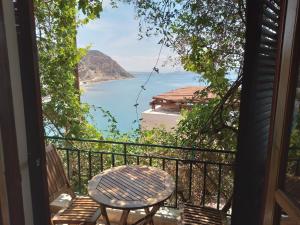 a table and chairs on a balcony with a view of the ocean at Loggia in Agia Galini