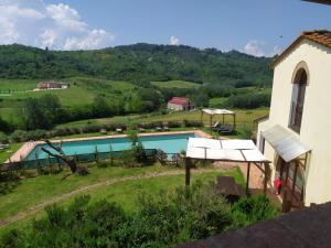 vistas a una piscina con montañas de fondo en La Casina- Podere della Collina, en Collelungo