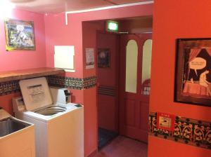 a laundry room with a washing machine and a sink at Southern Laughter Backpackers in Queenstown