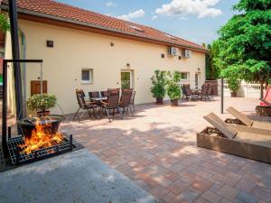 eine Terrasse mit einer Feuerstelle, einem Tisch und Stühlen in der Unterkunft Duna Apartments Štúrovo in Štúrovo