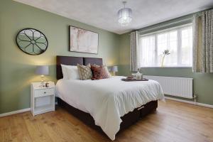 a bedroom with a large bed with green walls at Lyndhurst Forest Edge - Sleeps 6 in Lyndhurst