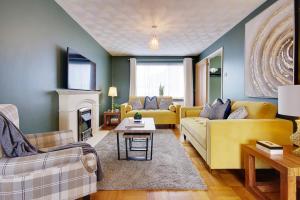 sala de estar con muebles de color amarillo y chimenea en Lyndhurst Forest Edge - Sleeps 6, en Lyndhurst