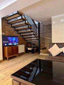 a living room with a spiral staircase and a tv at Woodland Borjomi in Borjomi