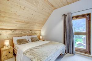 Un dormitorio con una cama y una ventana grande. en Neige et Soleil 3eme, en Morzine