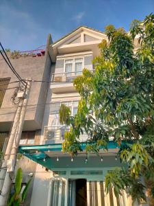 une maison blanche avec un arbre en face dans l'établissement TN's House, à Đà Nẵng