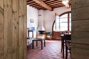 una sala de estar con una mesa y una chimenea en La Casina- Podere della Collina, en Collelungo