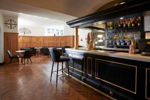 a bar with tables and chairs in a restaurant at The Crown Hotel in Weymouth