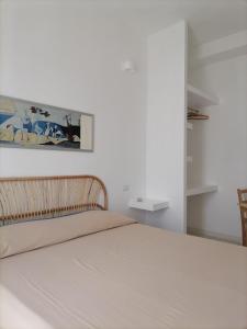 a bedroom with a bed and a painting on the wall at Casa Quieta in Marina di Camerota