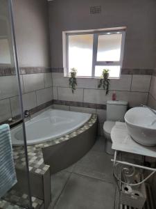 La salle de bains est pourvue d'une baignoire, d'un lavabo et de toilettes. dans l'établissement Bella Vista at Village-Living, à Koringberg