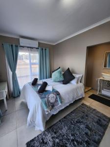 - une chambre avec un grand lit blanc et une fenêtre dans l'établissement Bella Vista at Village-Living, à Koringberg