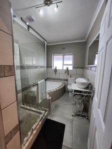 a bathroom with a tub and a toilet and a sink at Bella Vista at Village-Living in Koringberg