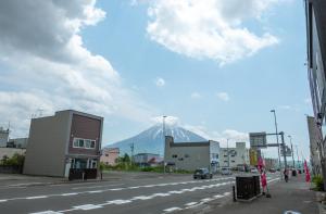 a snow covered mountain in the background of a street at Ezo Fujiya Niseko House in Kutchan