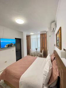 ein Schlafzimmer mit einem großen Bett in einem Zimmer in der Unterkunft Centrum Hotel in Tirana