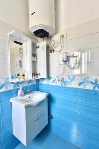 ein blaues Badezimmer mit einem Waschbecken und einem Spiegel in der Unterkunft Centrum Hotel in Tirana