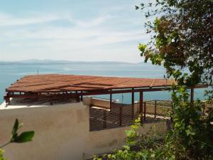 a building with a roof with the ocean in the background at Loggia in Agia Galini