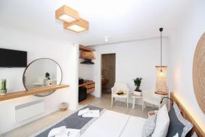 a living room with a bed and a mirror at Harmony Boutique Hotel in Mýkonos City