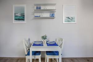 a white dining room with a blue table and chairs at VERSILIA MIA - beach at 8min by walk! new rooms! air condition! in Viareggio +19 photos