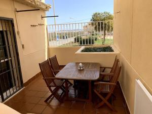 a table and chairs on a balcony with a window at Apartamento dúplex Cabo de Gata in El Cabo de Gata