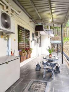 un patio con una mesa, un banco y una mesa en AaronL Homestay, en Kota Kinabalu