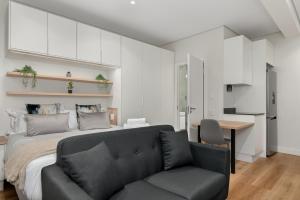 a bedroom with a bed and a couch and a table at The Carrington Aparthotel by Totalstay in Cape Town