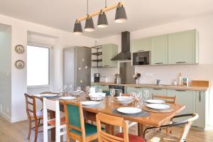 a kitchen and dining room with a wooden table and chairs at Vacances et détente en famille in Plovan +33 photos