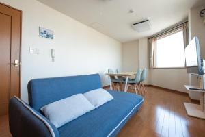a living room with a blue couch and a table at Ezo Fujiya Niseko House in Kutchan