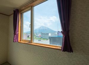 a window with a view of a mountain at Ezo Fujiya Niseko House in Kutchan