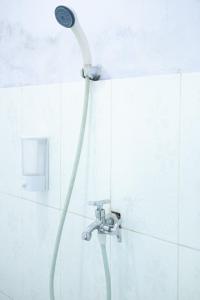 een douche met een douchekop in de badkamer bij Mentigen Homestay in Ngadisari