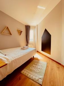 een slaapkamer met een bed met een tapijt en een raam bij BARCELONA73 By Vigovacaciones in Vigo