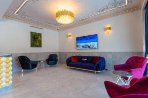 uma sala de espera com sofás e uma mesa e cadeiras em W Regal Boutique Hotel&Spa em Mamaia