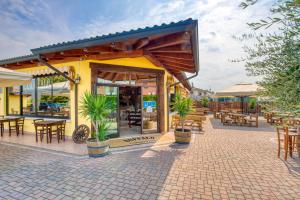 patio ze stołami i krzesłami oraz restaurację w obiekcie Appartamenti Villa Campo Rosso w mieście Colà di Lazise