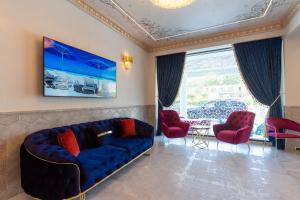 a living room with a blue couch and two red chairs at W Regal Boutique Hotel&Spa in Mamaia