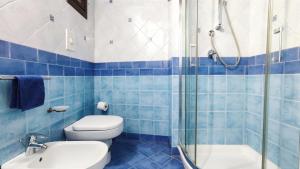 a blue tiled bathroom with a toilet and a shower at Porto Centro Storico Spiaggia Wi-Fi&Self Check-in in Castellammare del Golfo +3 photos