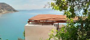a house with a roof on top of a body of water at Loggia in Agia Galini +16 photos