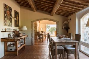 een eetkamer met een houten tafel en stoelen bij Dimora Santa Margherita - Relais di Charme in Cinigiano