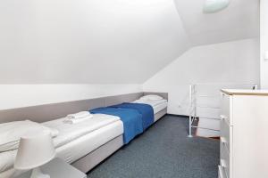 2 camas en una habitación con paredes blancas en Domki LEŚNA POLANA en Jastrzębia Góra