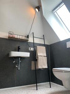 ein Bad mit einem Waschbecken, einem WC und einer Lampe in der Unterkunft steenkampstudios LOFT in Hamburg