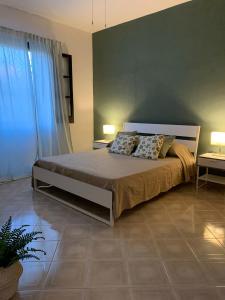 una camera con un letto e due tavoli e due lampade di Villa Ale a Fontane Bianche