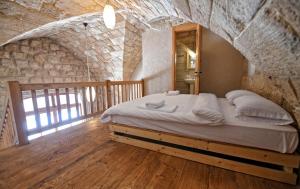 a bedroom with a large bed in a stone wall at Old Town Guesthouses in Batroûn