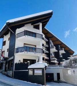 a building with snow on the ground in front of it at Triplex in Villars Centre with Parking in Villars-sur-Ollon